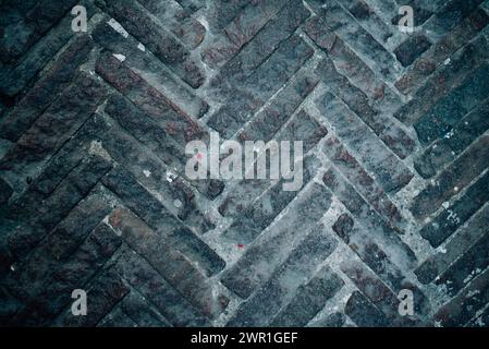 cobblestone street, ancient paved road made of rectangular stones laid in a ladder Stock Photo