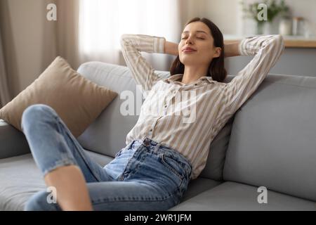 Woman relaxing on couch, serene and content Stock Photo