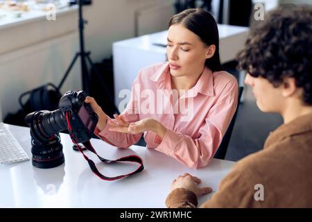 Model discussing photo results with female photographer in studio setting Stock Photo