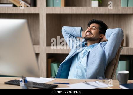 Relaxed Indian Businessman Resting Leaning Back In Chair At Office Stock Photo