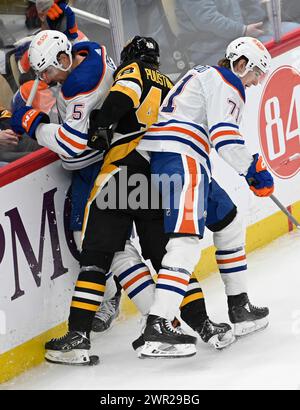 Pittsburgh, United States. 10th Mar, 2024. Edmonton Oilers center Ryan McLeod (71) and Edmonton Oilers defenseman Cody Ceci (5) sandwiches Pittsburgh Penguins right wing Valtteri Puustinen (48) along the boards during the second period at PPG Paints Arena in Pittsburgh on Sunday, March 10, 2024. Photo by Archie Carpenter/UPI. Credit: UPI/Alamy Live News Stock Photo