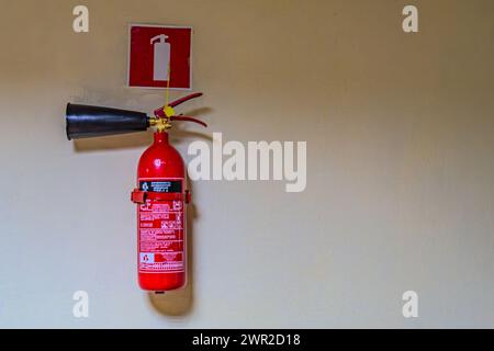 fire extinguishers available in fire emergencies. Fire extinguisher on the gray wall Kharkiv Ukraine 05-05-2023 Stock Photo