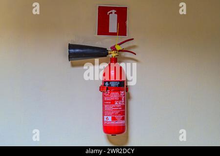 fire extinguishers available in fire emergencies. Fire extinguisher on the gray wall Kharkiv Ukraine 05-05-2023 Stock Photo