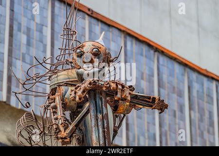 robot sculpture in the park, a robot resembling an iron lumberjack, assembled from antique iron parts. Kharkiv Ukraine 05-05-2023 Stock Photo