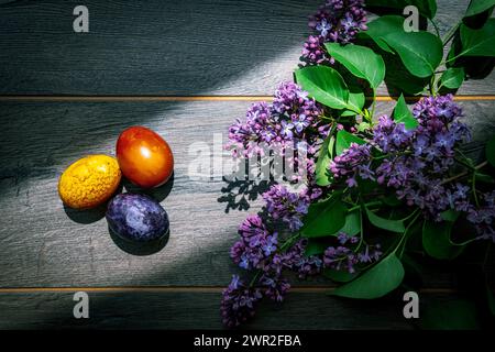 Easter eggs and lilac flowers on a rustic wooden floor Stock Photo