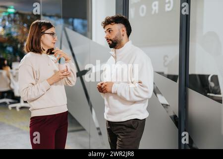 A group of professionals from different generations and backgrounds discussing business strategies and brainstorming ideas in a corporate office. Stock Photo
