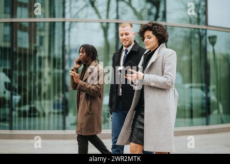 Diverse group of professionals walking and using smart phones outside. Stock Photo