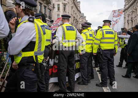 London, Westminster, UK. 9th Mar, 2024. Metropolitan Police officers move Congolese demonstrators out of the street during the rally. British Congolese protest against mining exploitation and the abuse of women by the Rwandan military in the Democratic Republic of Congo. The Protestors march from the BBC London headquarters in Portland Place along Regent Street to Trafalgar Square. Mobile phone and computer equipment shops are targeted as they are seen as the largest consumer of the disputed valuable minerals. (Credit Image: © James Willoughby/SOPA Images via ZUMA Press Wire) EDIT Stock Photo