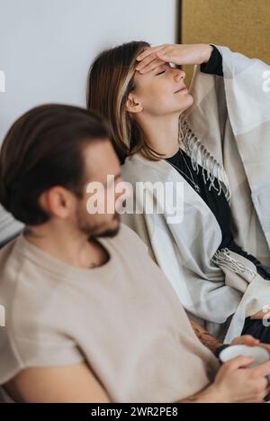 Two colleagues taking a break. Woman massaging her eyes and forehead while resting from work. Stock Photo