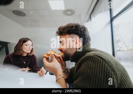 Multiracial colleagues enjoying a pizza break, fostering teamwork and refreshment during their successful work day. Stock Photo