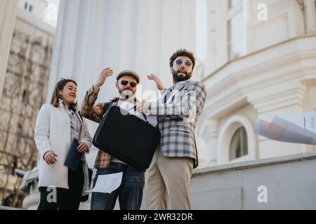 Creative young professionals engaging in a collaborative discussion outdoors in a vibrant city setting. Stock Photo
