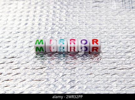 Mirror word composed with cubes on silver background Stock Photo
