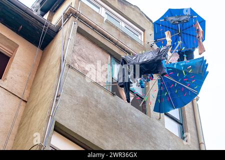 Clothes drying rack in the shape of an umbrella in use on the facade of a residential building in Bilbao. Stock Photo