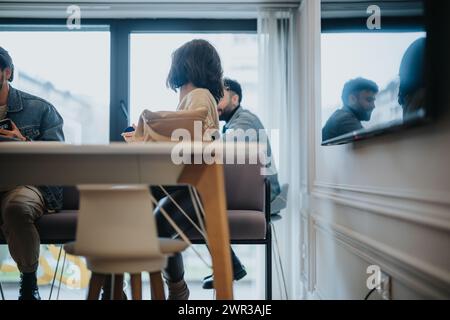 A modern, well-lit office space capturing the essence of a casual business meeting among diverse professionals. Stock Photo
