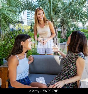 Three friends talking and laughing together. Scene is lighthearted and cheerful Stock Photo