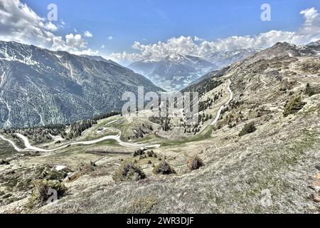 Photo with reduced dynamic saturation HDR of mountain pass alpine pass alpine mountain road alpine road pass road pass in Italian Alps view from pass Stock Photo
