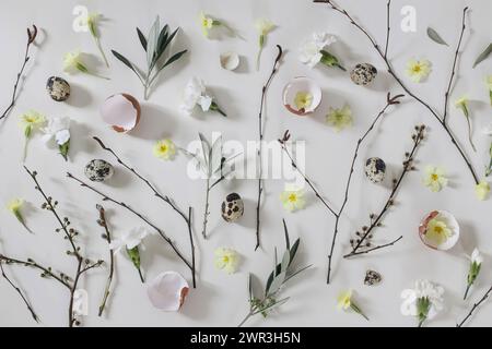 Easter floral composition. Yellow primrose, white carnation flowers. Birch, olive tree branches, willow catkins twigs. Quail, hen eggs shells isolated Stock Photo