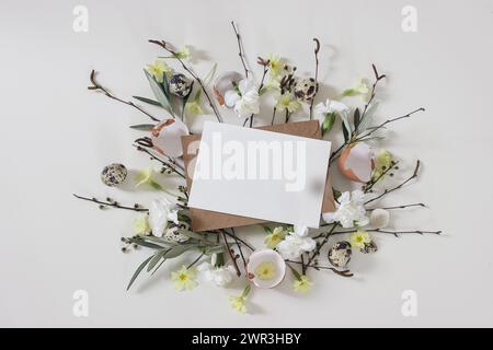 Spring greeting card, Easter invitation mockup. Primrose, white carnation flowers. Birch, olive tree branches, willow catkins twigs. Quail, hen eggs Stock Photo