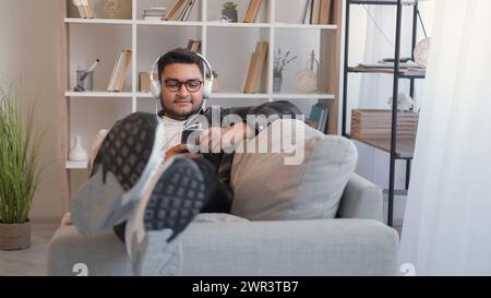 Mobile music enjoying man headphones couch home Stock Photo
