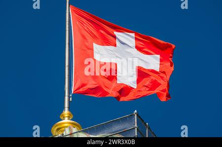 Eine Schweizer Fahne weht auf dem Bundeshaus im Wind. (Bern, Schweiz, 03.08.2023) Stock Photo