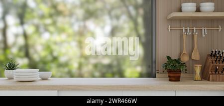 A presentation space for displaying products on a wooden kitchen countertop against the window features decorative plants and kitchenware in a neutral Stock Photo