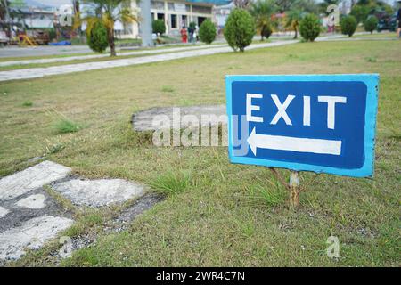 Close up Blue Hand-painted Exit arrow signboard on the ground Stock Photo