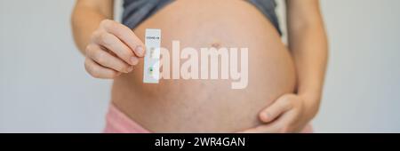 Pregnant woman making test. Close up of fingers holding express antigen covid corona test BANNER, LONG FORMAT Stock Photo