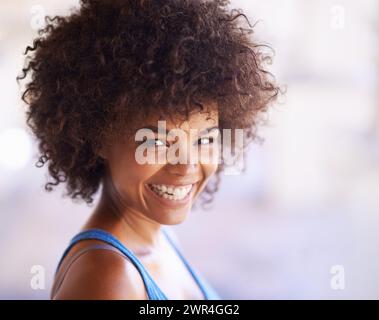 Woman, portrait and laughing in fashion with hair care, natural beauty and casual outfit in summer. African person, face and happy with afro hairstyle Stock Photo