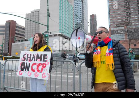 Pro-Tibet demonstrators hold placards expressing their opinion and chant slogans at a rally near the building of the Consulate General of the People's Republic of China in New York during the 65th Tibetan Uprising Day. Demonstrators rallied in Manhattan, New York City demanding Tibet's independence from China. The Tibetan Uprising Day marks the day in 1959 when thousands of Tibetans in Tibet surrounded the palace of the current and 14th Dalai Lama. The Dalai Lama is the spiritual Buddhist leader of Tibetans worldwide. The Tibetans surrounded the palace in 1959 to protect the Dalai Lama due to Stock Photo