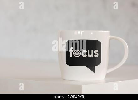 The message focus on a speech bubble printed on a coffee mug over the table. Focusing and concentration concept. Stock Photo