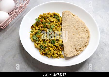 Anda Masala Bhurji or Spicy Indian scrambled eggs with bread or Bun Pav, a popular street food in Mumbai. Served in white plate along with copy space Stock Photo