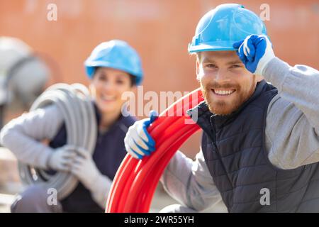 female and male workers with electrical cable Stock Photo