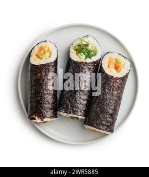 A white plate is placed on a white table, with an assortment of sushi neatly arranged on top. The sushi pieces glisten under the light, showcasing the Stock Photo