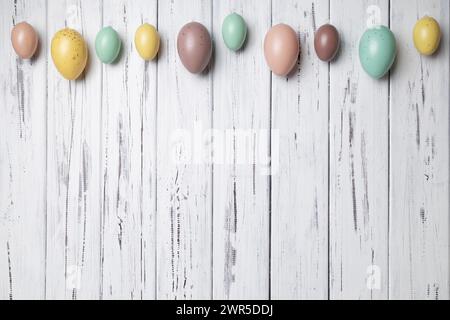 Multicoloured Easter eggs on white vintage aged wooden background. Copy space Stock Photo