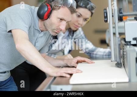 two carpenters making holes in wood plank Stock Photo