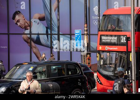 With months before the 2024 Paris Olympics, members of the public pass beneath a huge image of Team GB gymnast and previous Olympic gold medalist, Max Whitlock outside Coutts Bank on the Strand, on 8th March 2024, in London, England. Coutts Bank (and Natwest Bank) are currently Team GB's official corporate partners. Stock Photo