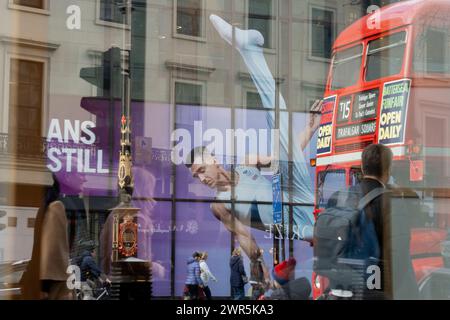 With months before the 2024 Paris Olympics, members of the public pass beneath a huge image of Team GB gymnast and previous Olympic gold medalist, Max Whitlock outside Coutts Bank on the Strand, on 8th March 2024, in London, England. Coutts Bank (and Natwest Bank) are currently Team GB's official corporate partners. Stock Photo