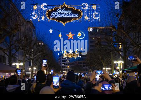 Happy Ramadan in Frankfurt am Main Der illuminierte Schriftzug Happy Ramadan leuchtet am Abend des 10.03.2024 als Teil einer Lichtinstallation, die in Frankfurt am Main über die Große Bockenheimer Straße  Fressgass  gespannt ist. Der Ramadan ist der Fastenmonat der Muslime und neunter Monat des islamischen Mondkalenders. In ihm wurde nach islamischer Auffassung der Koran herabgesandt. Im Jahr 2024 beginnt Ramadan am Abend des 10. März und endet am Abend des 09. April. Frankfurt am Main Große Bockenheimer Straße Hessen Deutschland *** Happy Ramadan in Frankfurt am Main The illuminated lettering Stock Photo