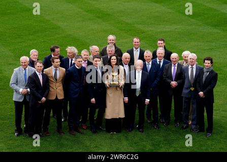 Jockey Rachael Blackmore (centre) holds the Gold Cup trophy as she poses for a photo with previous Gold Cup winning jockeys at Cheltenham Racecourse, ahead of the 2024 Cheltenham Festival, which begins tomorrow. Picture date: Monday March 11, 2024. Stock Photo