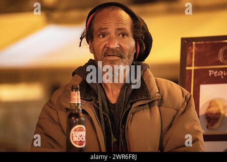 An elderly Rastafarian without a roof sits at the bar, exuding wisdom and resilience amidst adversity. Stock Photo