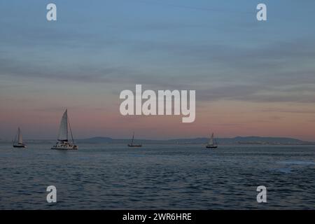 The sailboats on a vast sea during sunset Stock Photo