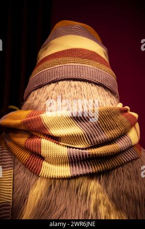 A charming winter-themed puppet displayed in a shop window, adorned with a cozy scarf and hat, exuding seasonal cheer Stock Photo