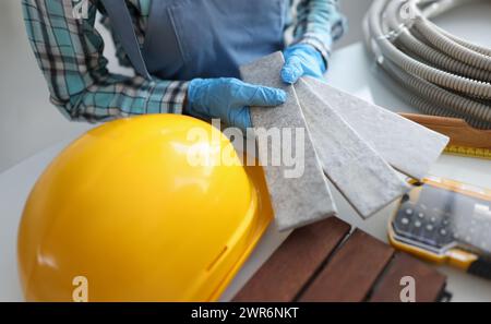 Builder holding gray tiles for bathroom in workshop closeup Stock Photo
