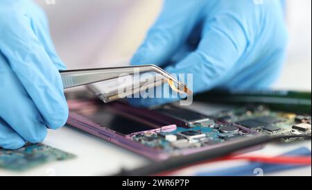 Master repairman inserting microchip into mobile phones closeup Stock Photo