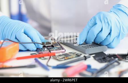 Master repairman inserting microchip into mobile phone closeup Stock Photo