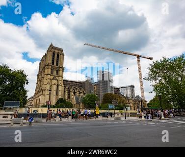 Paris, France - July 23 2022: Notre-Dame in Paris under construction due to fire in 2019; with crowded tourists Stock Photo