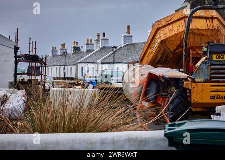 Single storey cottages in the background, and repairs, maintenance and general building work come to a halt on Ellenabeich. Scotland Stock Photo