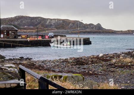 The small empty Easdale passenger ferry reverses away from the passenger slipway on Ellenabeich, Scotland Stock Photo