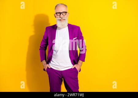Photo portrait of confident man wearing blue suit glasses smiling happy isolated bright yellow color background Stock Photo