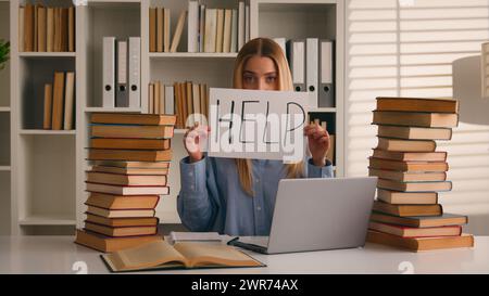 Confused tired student girl teen high school pupil exhausted stressed woman with books laptop studying in university collage library showing banner Stock Photo